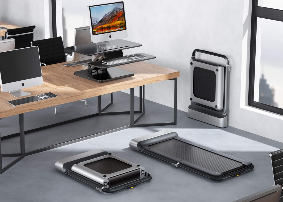 The Walking Pad is folded and stored beneath the desk.